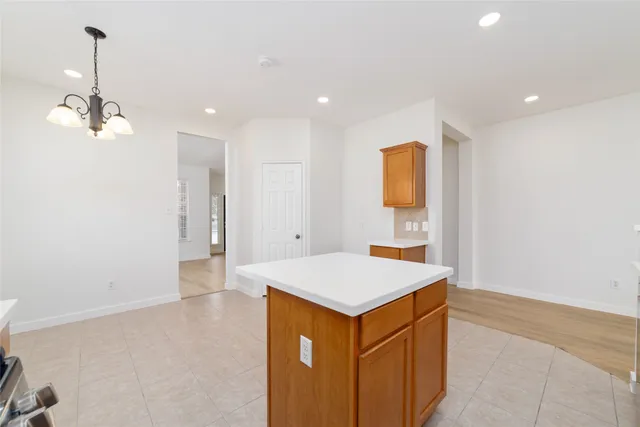 a view of an empty room with a kitchen