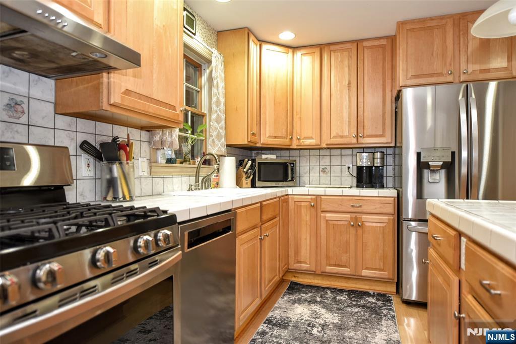 84 West Midland Avenue Paramus, NJ 07652 - Photo 12 of 37 a kitchen with stainless steel appliances granite countertop a stove a sink and a refrigerator