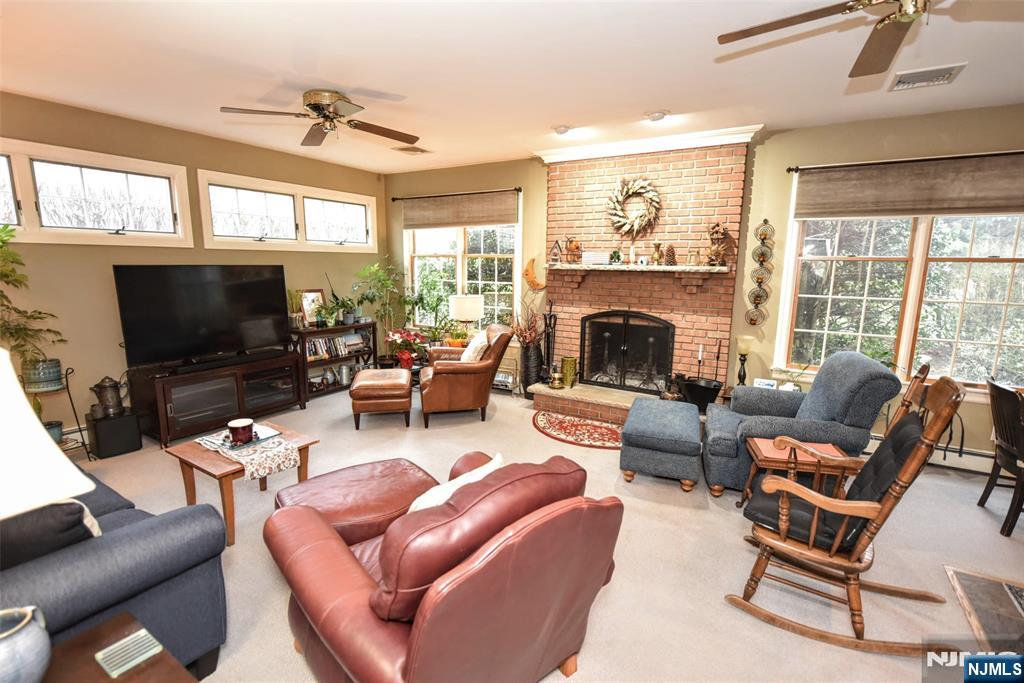 84 West Midland Avenue Paramus, NJ 07652 - Photo 16 of 37 a living room with furniture a fireplace and a flat screen tv
