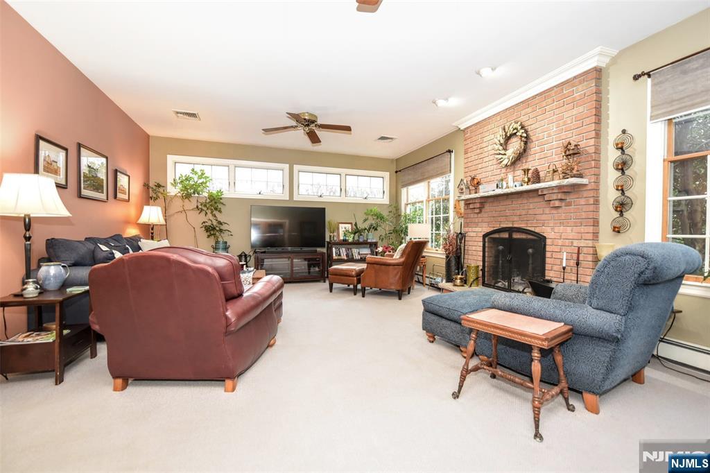 84 West Midland Avenue Paramus, NJ 07652 - Photo 17 of 37 a living room with furniture a fireplace and a flat screen tv