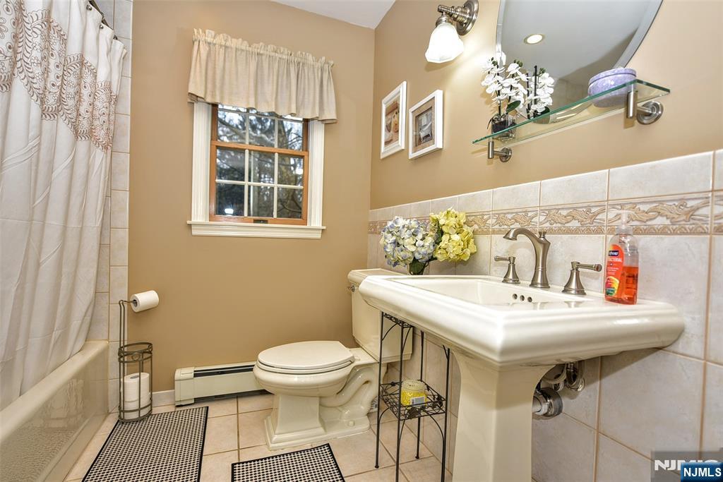 84 West Midland Avenue Paramus, NJ 07652 - Photo 22 of 37 a bathroom with a sink a toilet and a mirror