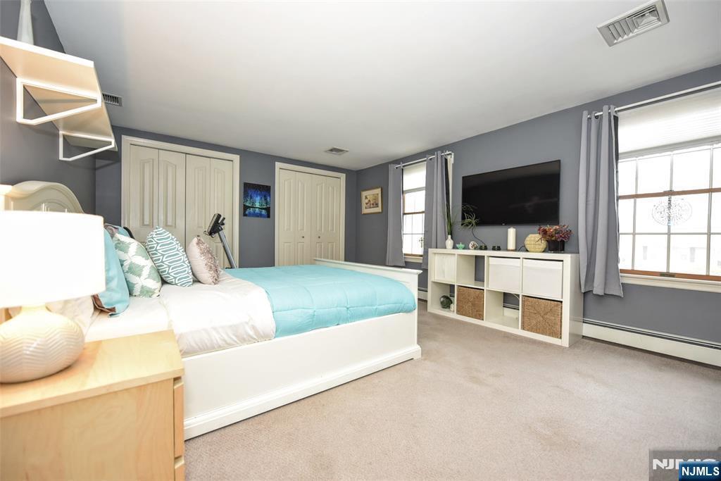 84 West Midland Avenue Paramus, NJ 07652 - Photo 25 of 37 a bedroom with a bed and a flat screen tv
