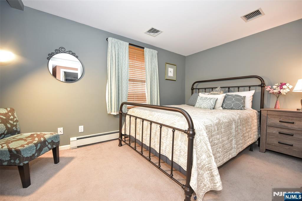 84 West Midland Avenue Paramus, NJ 07652 - Photo 26 of 37 a bedroom with a bed and a chandelier