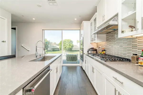 a kitchen with stainless steel appliances a sink stove and cabinets