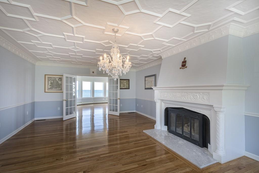 481 Jerusalem Road Cohasset, MA 02025 - Photo 12 of 30 a view of a livingroom with a fireplace a chandelier and wooden floor