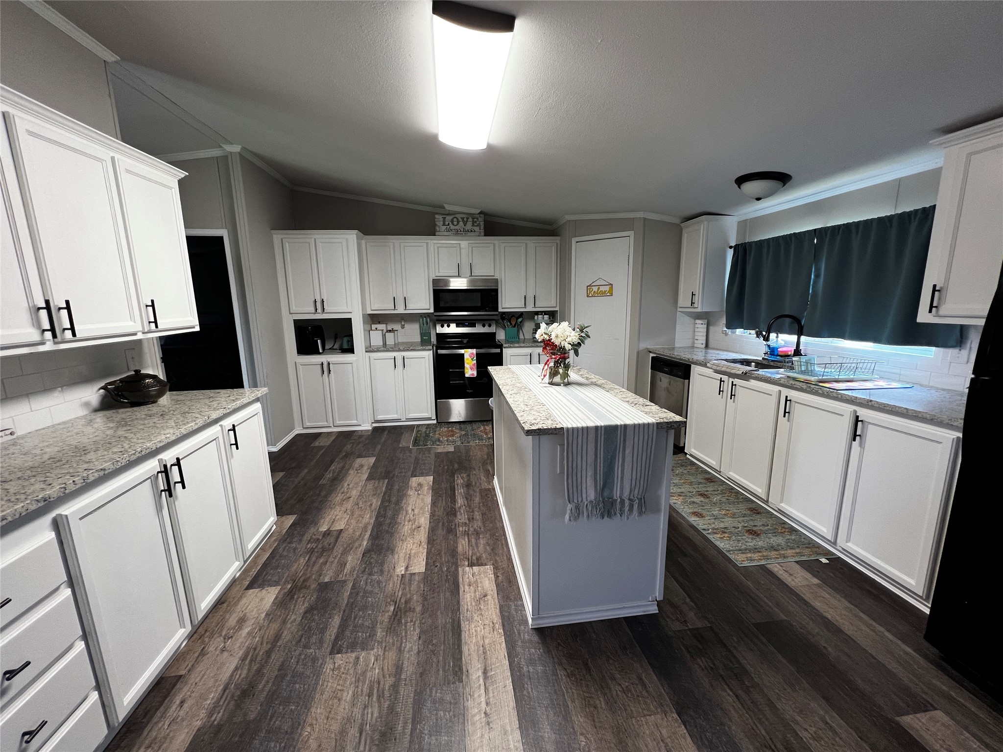 2346 Pr 1105 Midway, TX 75850 - Photo 10 of 25 a large kitchen with a stove a sink dishwasher a microwave oven and a stove with wooden floor