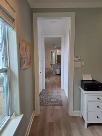 a view of a hallway to a livingroom and a living room with a mirror