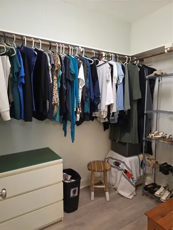 a view of walk in closet with clothes and shoes