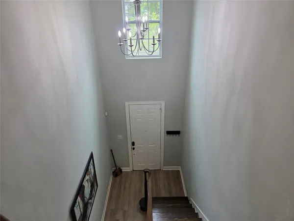 a view of a hallway with wooden floor and a window