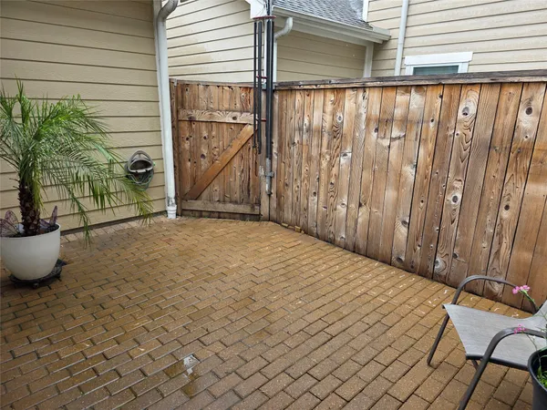 a view of a backyard with a patio and wooden fence