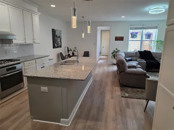 a living room with granite countertop furniture and a wooden floor