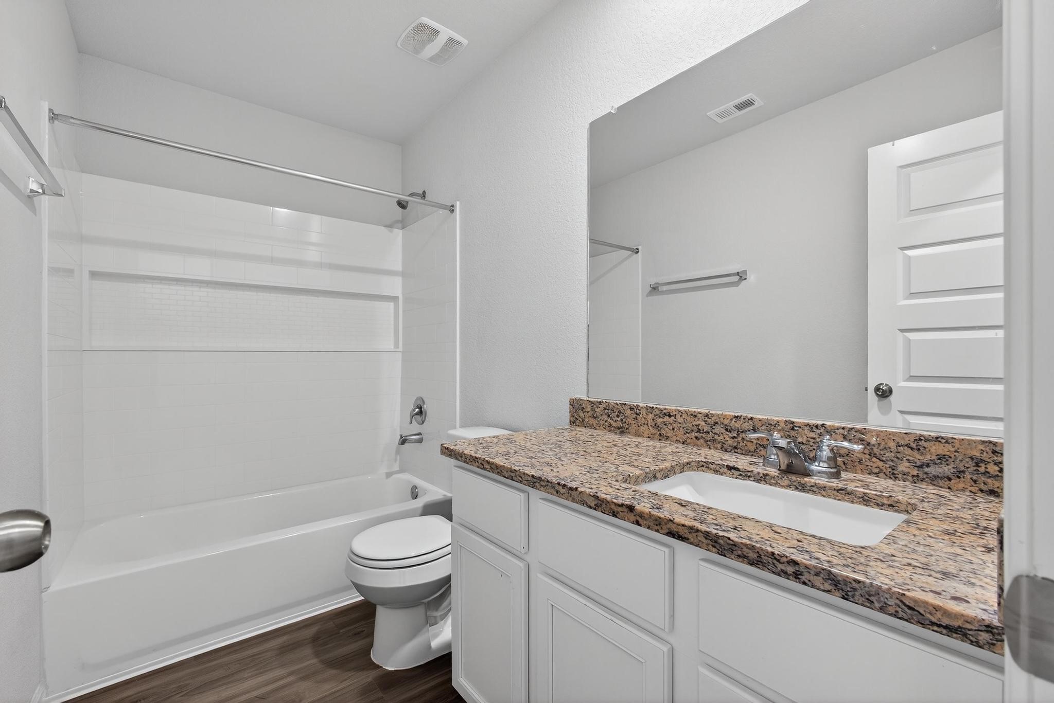 1409 Mount Bassie Trail Conroe, TX 77301 - Photo 15 of 26 a bathroom with a granite countertop sink toilet a mirror and shower