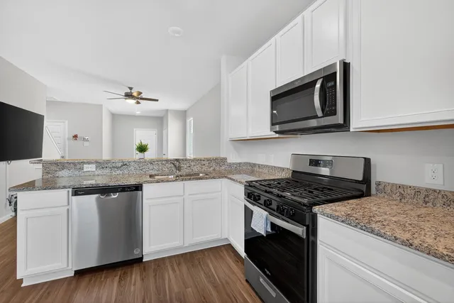 a kitchen with stainless steel appliances granite countertop a stove and a microwave