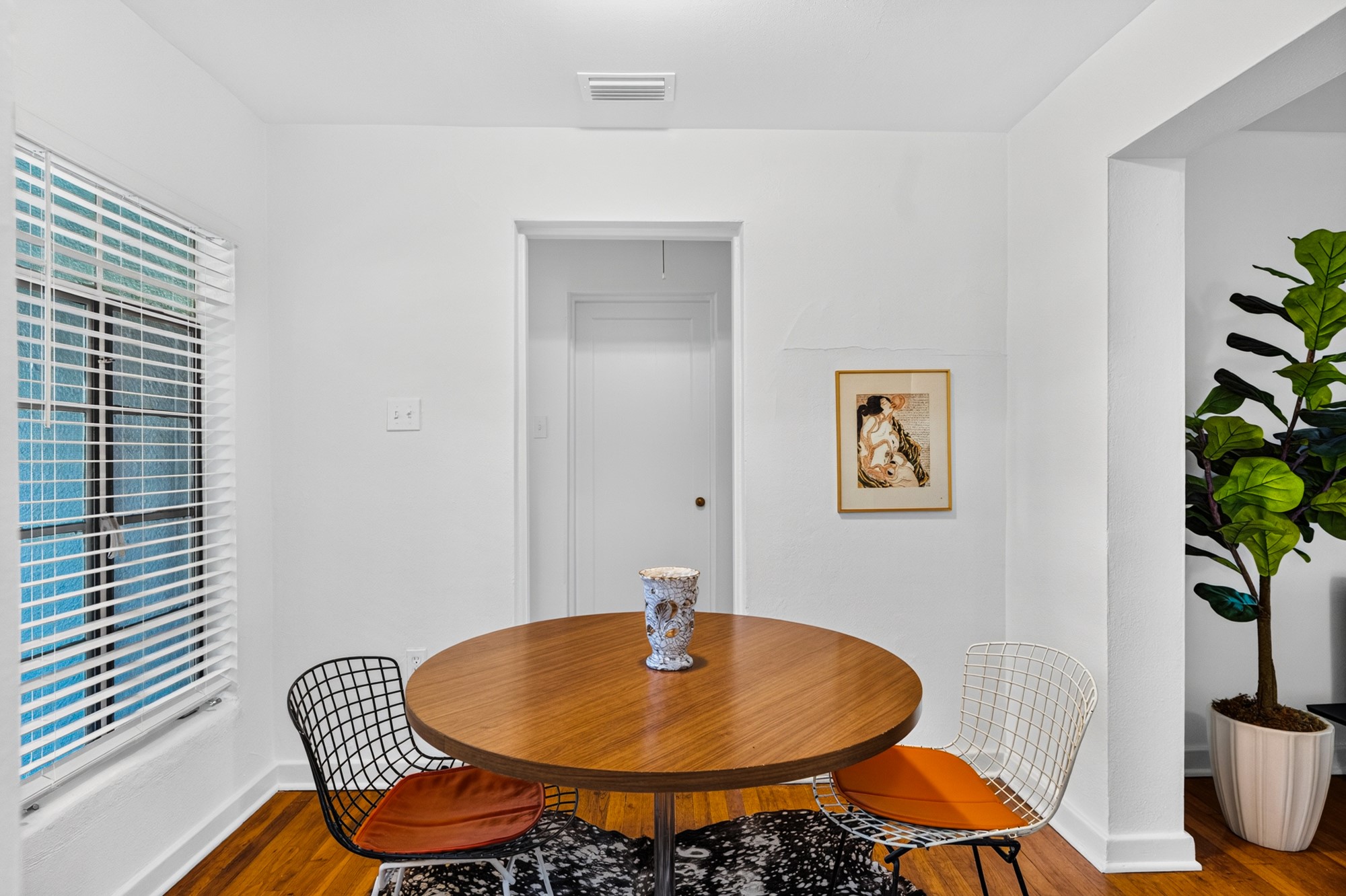 1302 Kirkwood Road, Unit B Austin, TX 78722 - Photo 6 of 21 A well-lit breakfast nook offers warmth and style, featuring rich hardwood floors and an inviting dining space.