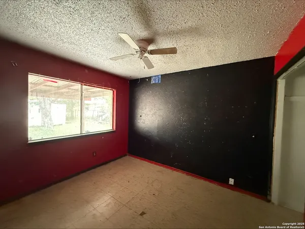 en empty room with windows and fan