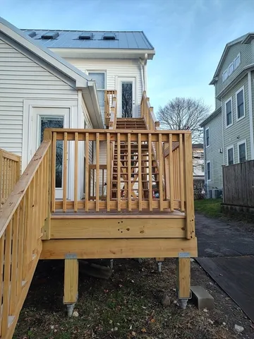 a view of a wooden house with a small deck and furniture