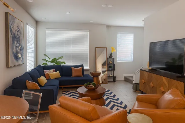 a kitchen with stainless steel appliances kitchen island granite countertop a refrigerator a sink dishwasher a dining table and chairs with wooden floor