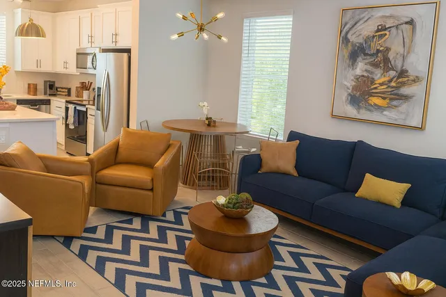 a kitchen with stainless steel appliances granite countertop a sink a stove and white cabinets