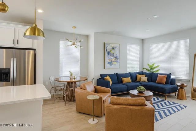 a kitchen with stainless steel appliances a table chairs refrigerator and sink