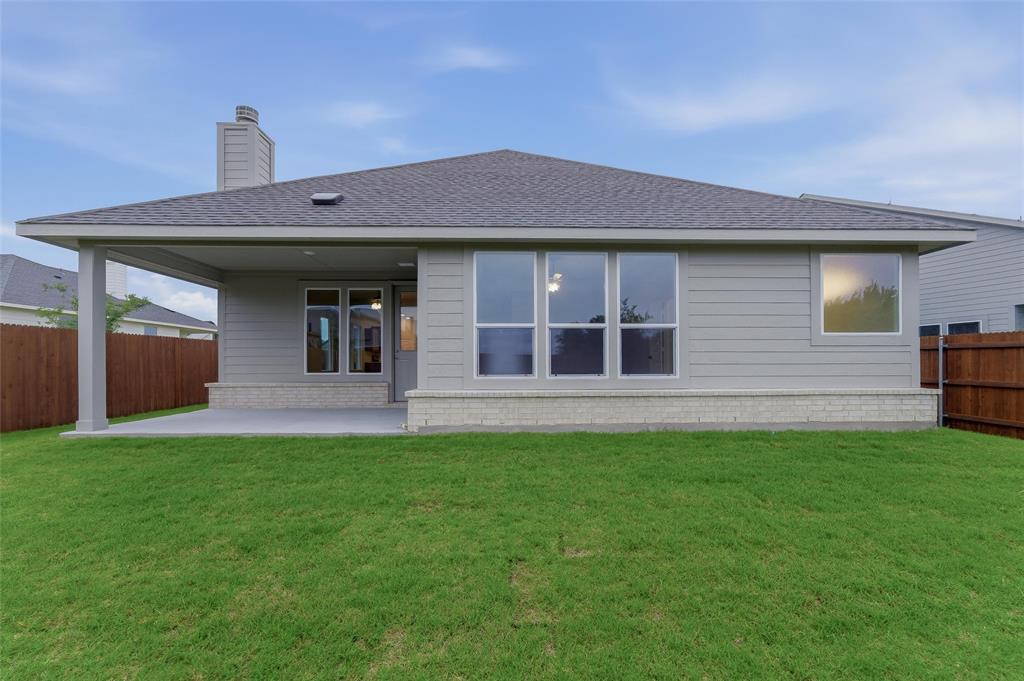 1237 Frio Drive Springtown, TX 76082 - Photo 23 of 25 Expansive green lawn bordering a covered patio area with a concrete slab