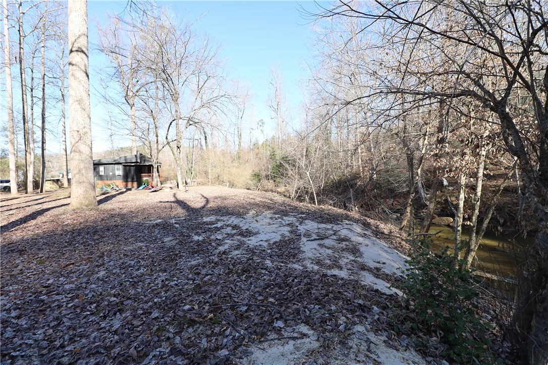 200 Laurel And Hardy Lake Road Marietta, SC 29661 - Photo 14 of 47 This tranquil setting features a cozy home nestled amongst mature trees and a serene creek.