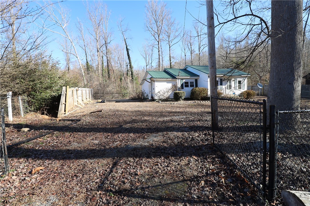 200 Laurel And Hardy Lake Road Marietta, SC 29661 - Photo 22 of 47 This charming home features a verdant roof and a fenced yard, perfect for outdoor enjoyment.