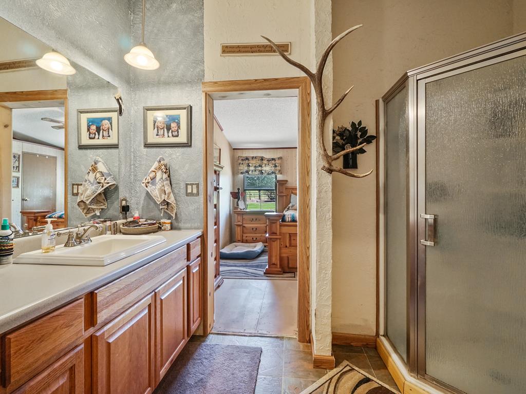 4805 Cedar Road Delta, CO 81416 - Photo 31 of 36 a bathroom with a sink a mirror and a shower