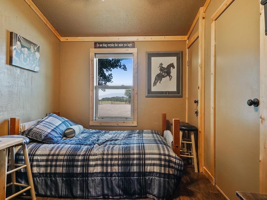 4805 Cedar Road Delta, CO 81416 - Photo 35 of 36 a bedroom with a bed and wooden floor