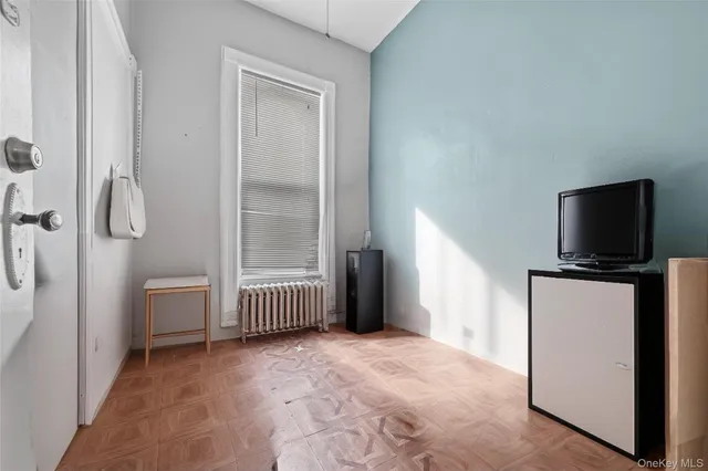 a spacious bedroom with a bed and a chandelier