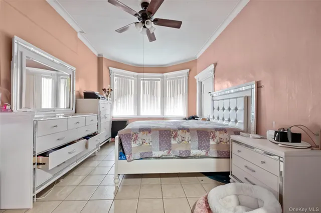 a bedroom with a bed and a flat tv screen on dresser