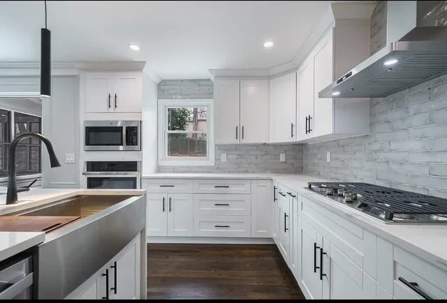 a kitchen with cabinets appliances and a sink