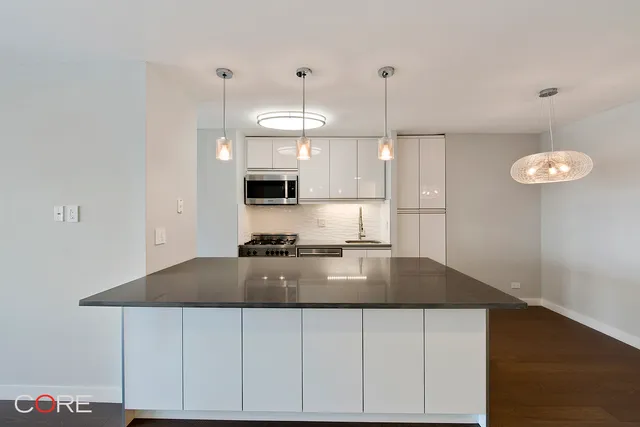 a kitchen with granite countertop a stove a sink and a refrigerator