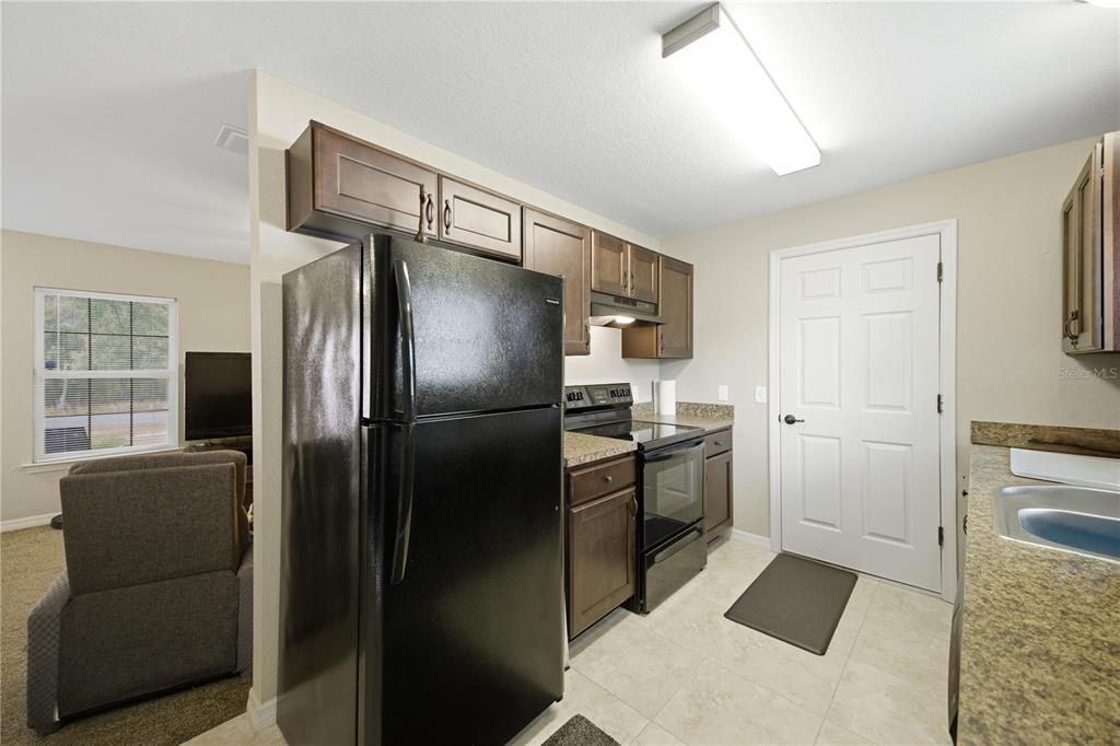 157 Spruce Road Ocala, FL 34472 - Photo 7 of 19 a kitchen with a refrigerator and a stove top oven