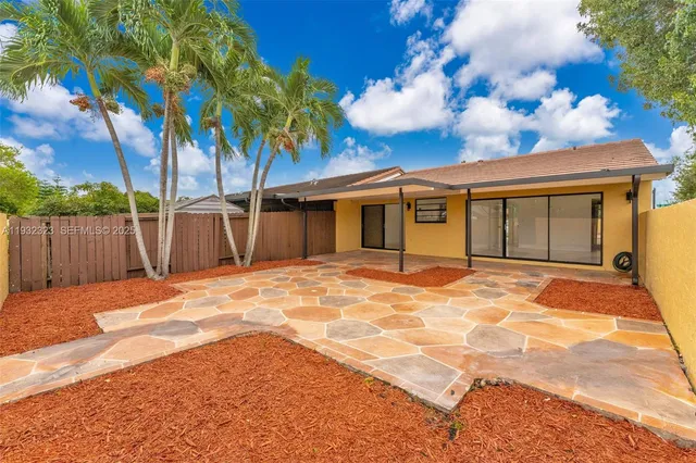 a view of a backyard with a large tree and wooden fence