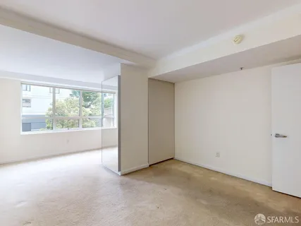 a view of a big room with windows and chandelier fan