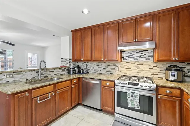 a kitchen with stainless steel appliances granite countertop a sink stove and cabinets