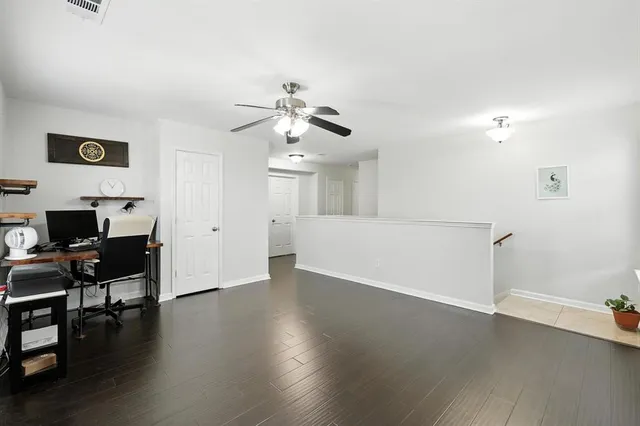 a view of a livingroom with wooden floor and a ceiling fan