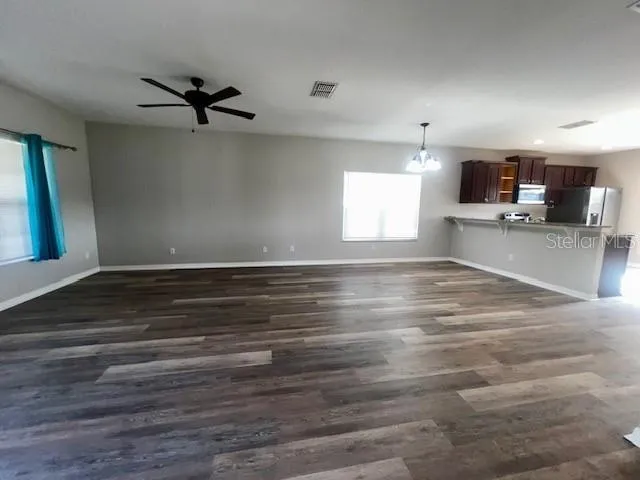 a view of a room with wooden floor and a ceiling fan