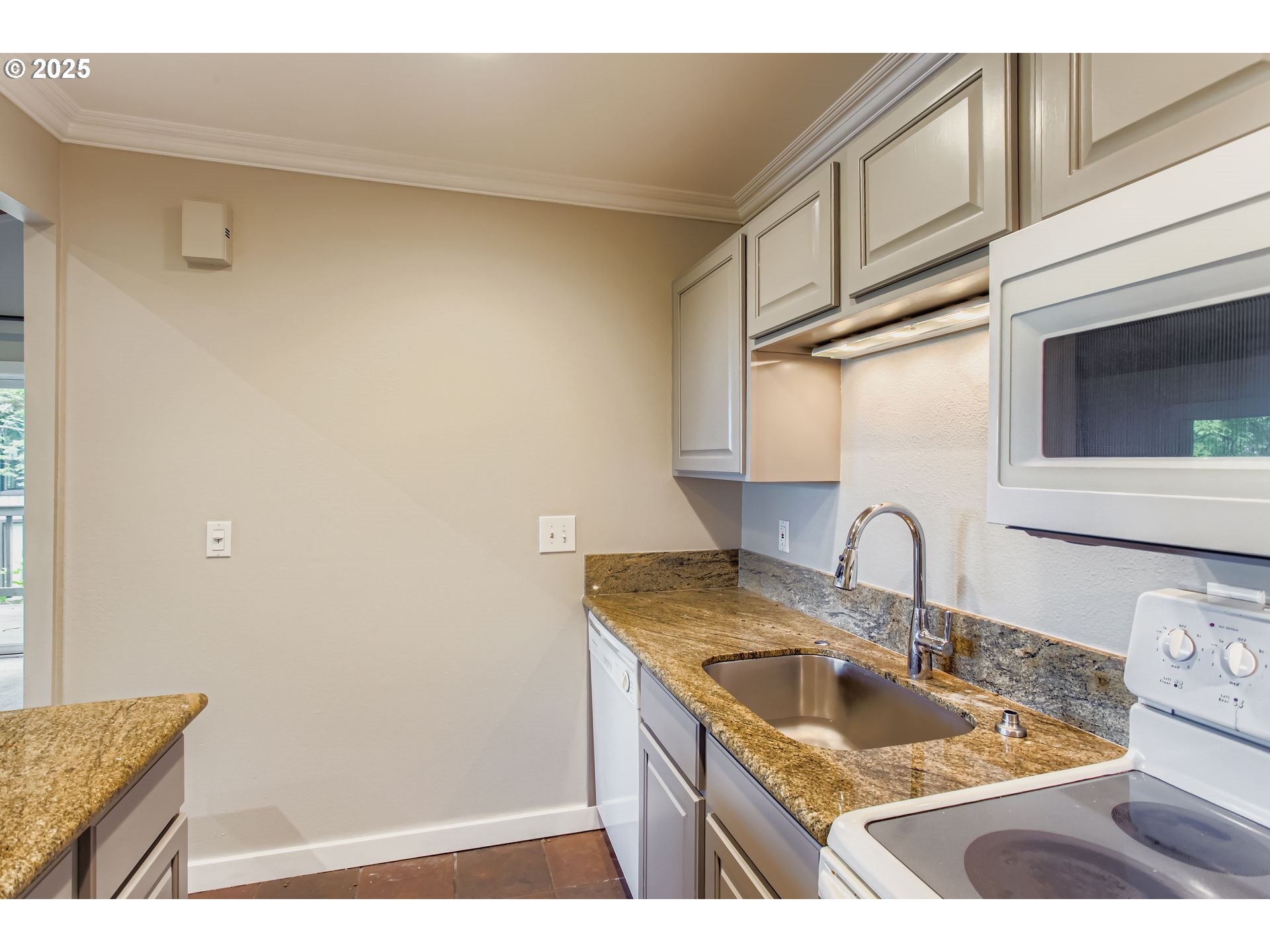 7514 Southwest Barnes Road, Unit A Portland, OR 97225 - Photo 12 of 24 a kitchen with a sink a stove and cabinets