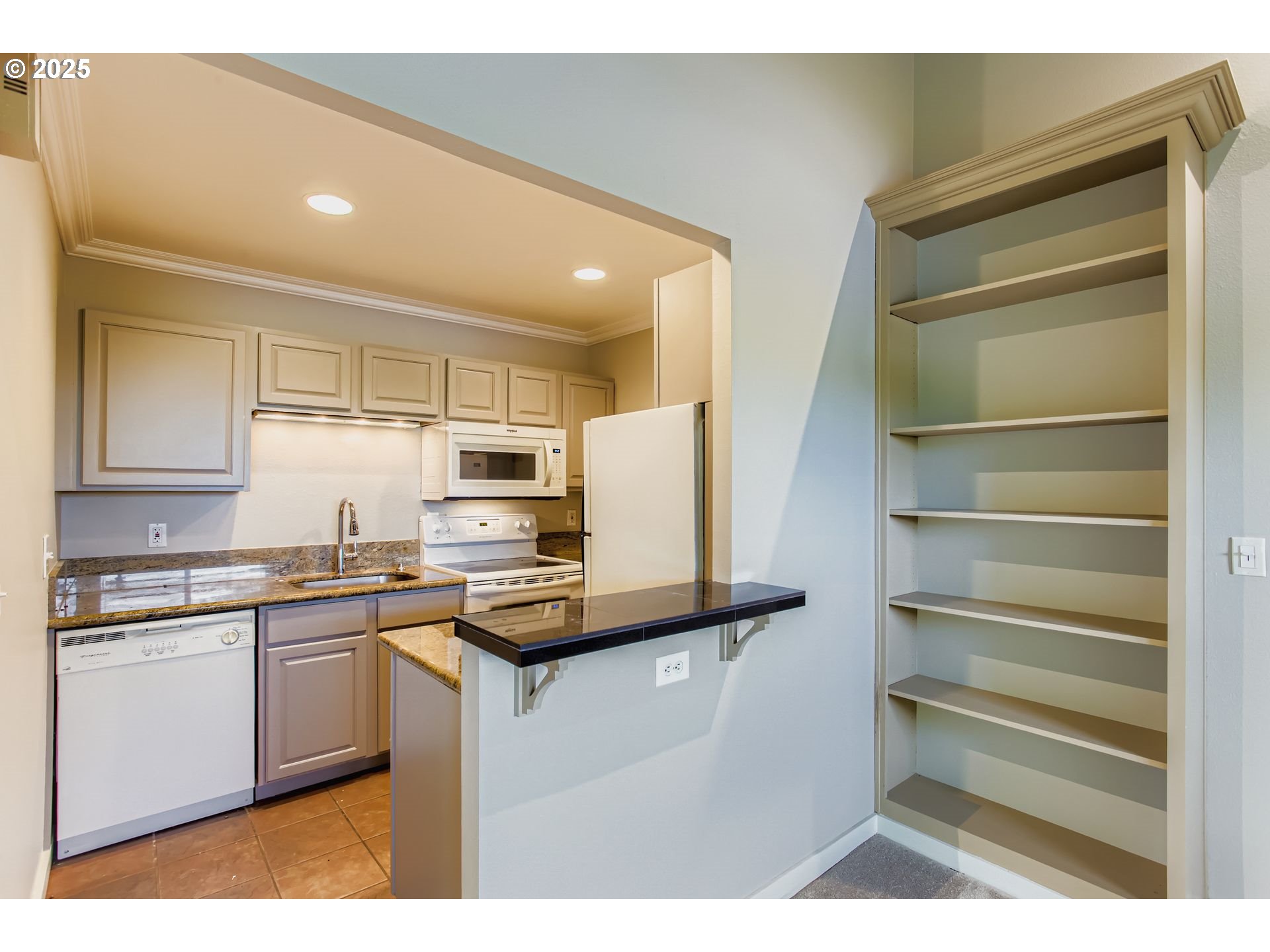 7514 Southwest Barnes Road, Unit A Portland, OR 97225 - Photo 8 of 24 a kitchen with kitchen island a sink appliances and cabinets