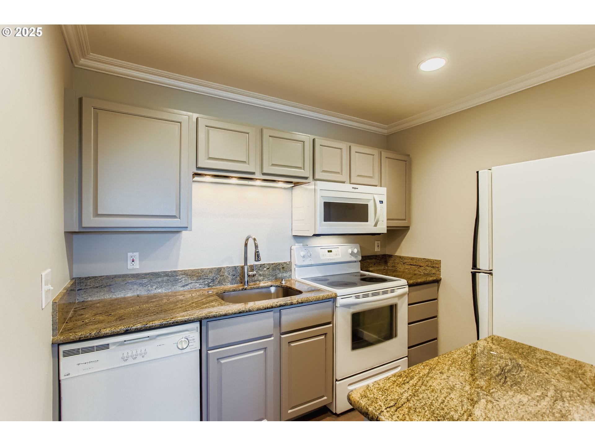 7514 Southwest Barnes Road, Unit A Portland, OR 97225 - Photo 9 of 24 a kitchen with stainless steel appliances granite countertop a sink stove and microwave