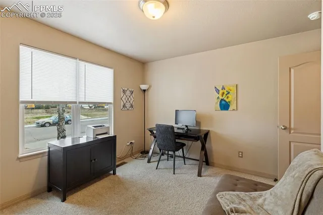 a view of a workspace with furniture and a window
