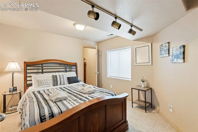 a bedroom with a large bed and a chandelier