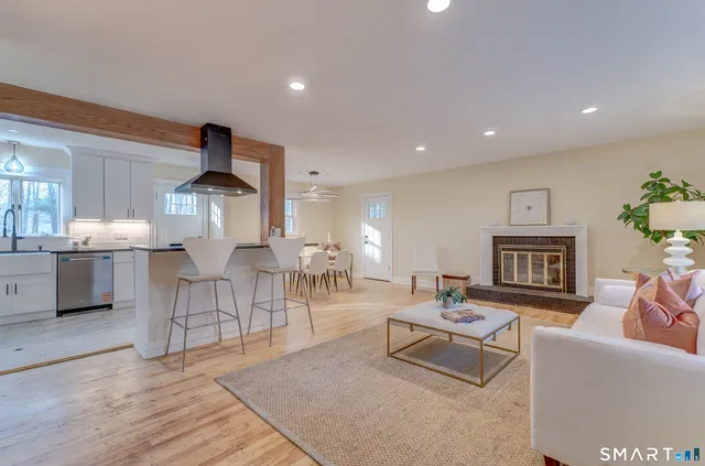 a living room with furniture a wooden floor and a fireplace