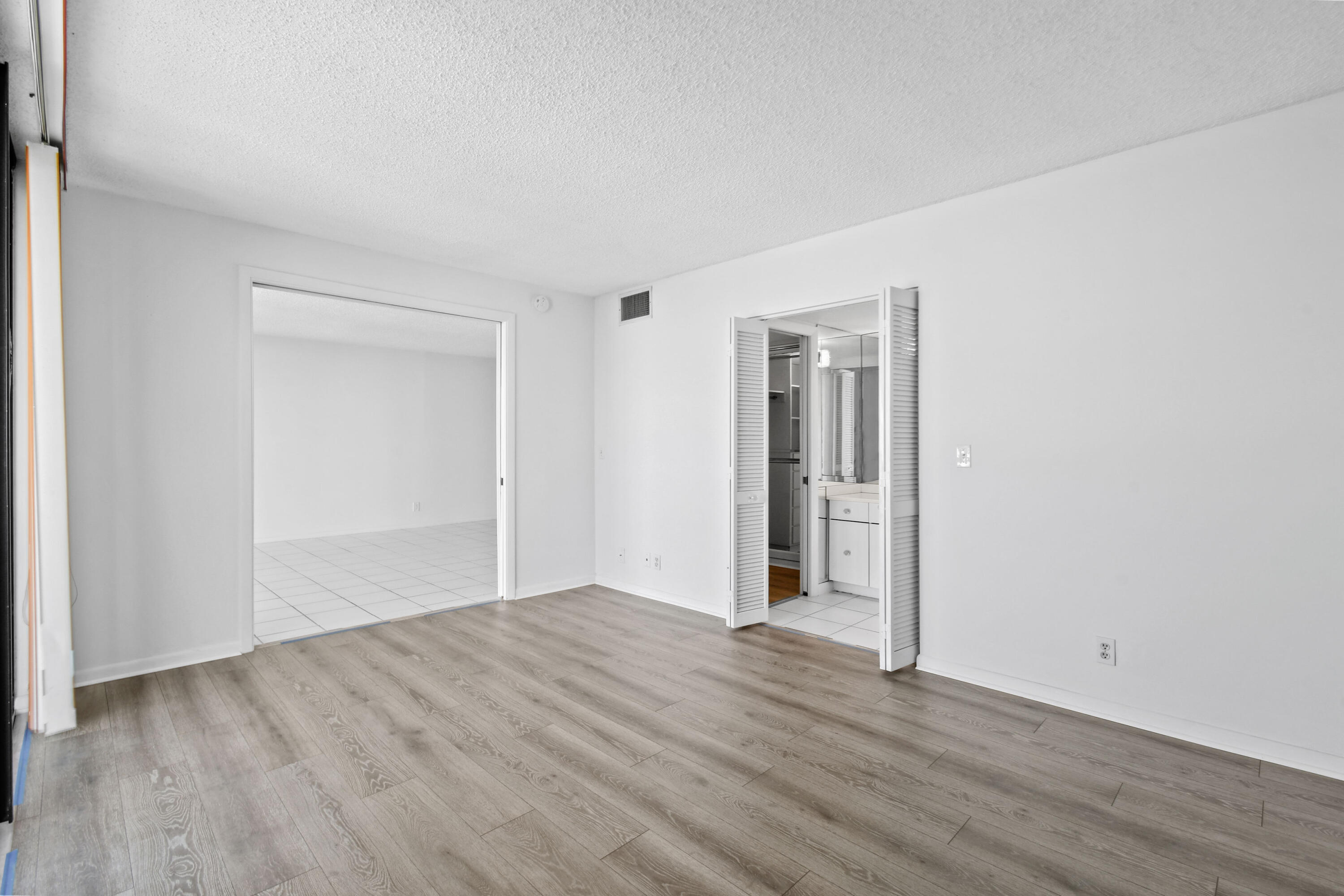 2425 Presidential Way, Unit 801 West Palm Beach, FL 33401 - Photo 12 of 41 a view of an empty room with wooden floor and closet