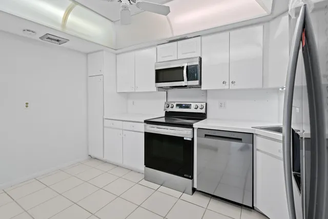 a kitchen with white cabinets stainless steel appliances and sink