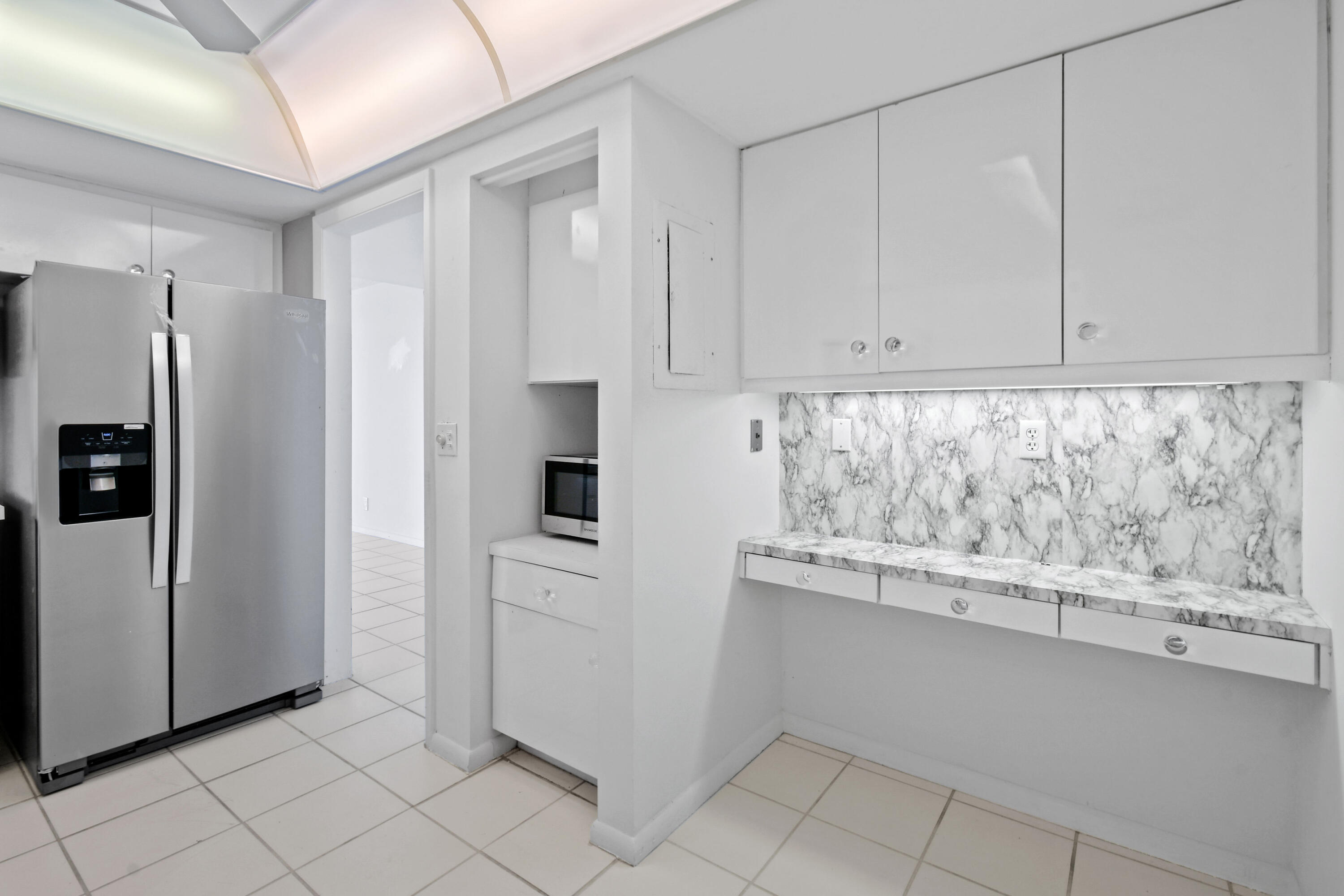 2425 Presidential Way, Unit 801 West Palm Beach, FL 33401 - Photo 4 of 41 a view of kitchen with refrigerator and window