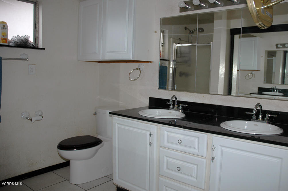 2218 Ralston Street Simi Valley, CA 93063 - Photo 9 of 23 a bathroom with a granite countertop sink a toilet and a mirror