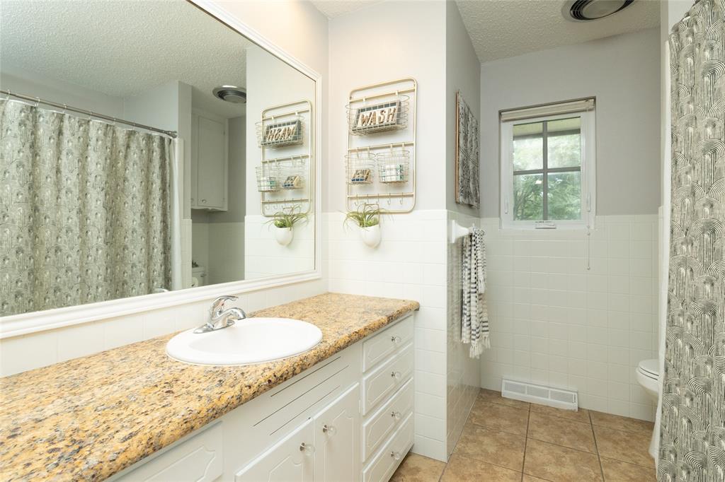 205 Timberlake Drive Azle, TX 76020 - Photo 15 of 40 a bathroom with a granite countertop sink and a mirror