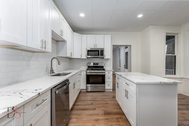 a kitchen with granite countertop a sink and steel stainless steel appliances